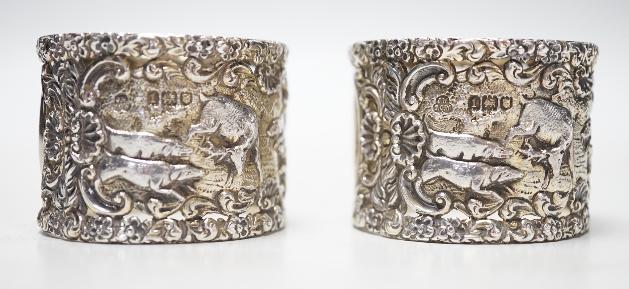 A pair of Edwardian silver serviette rings, pierced and embossed with deer hunting scenes, Wakely & Wheeler, London, 1906, 38mm.